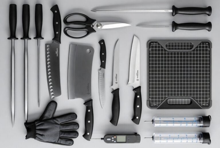 Seleção de acessórios para assados indispensáveis, incluindo termômetro digital para precisão, injetores de tempero e facas de corte com chaira para amolar."